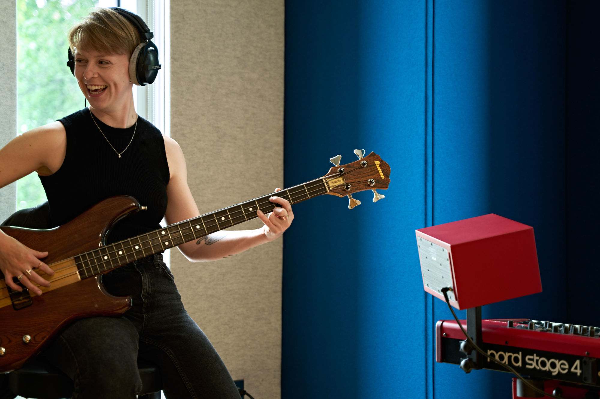 Student smiling while playing guitar